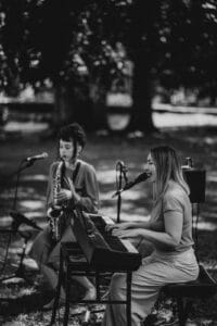 Das Duo vom Klang Salon mit Gesang, Saxophon und Piano spielt outdoor live auf einer Trauung